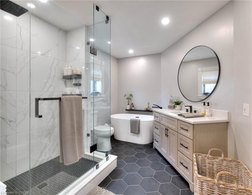 Spacious bathroom with a shower, bathtub, vanity sink, gray floor tiles, and white walls.